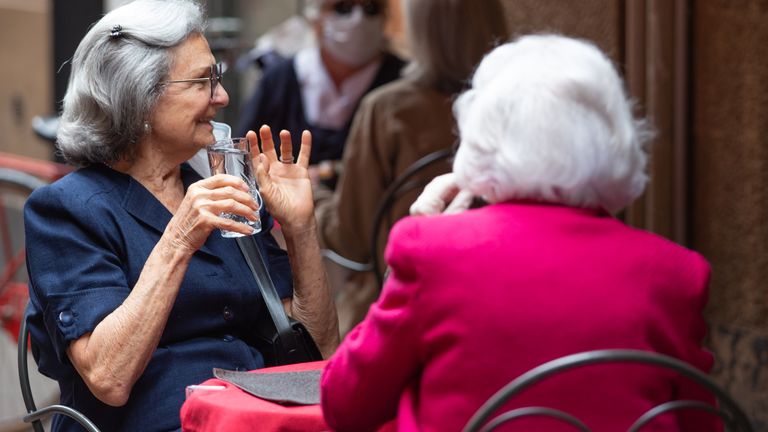 Des femmes sont vues en train de boire un verre en plein air alors que l'Italie a commencé à assouplir le verrouillage le 18 mars
