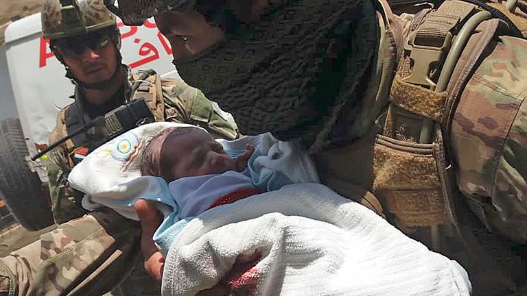 TOPSHOT - Un membre du personnel de sécurité afghan transporte un nouveau-né d'un hôpital, sur le site d'une attaque à Kaboul le 12 mai 2020. - Des hommes armés ont pris d'assaut un hôpital le 12 mai lors d'une attaque en cours dans la capitale afghane, Kaboul, un responsable du gouvernement et a déclaré un médecin en fuite. (Photo par STR / AFP) (Photo par STR / AFP via Getty Images)