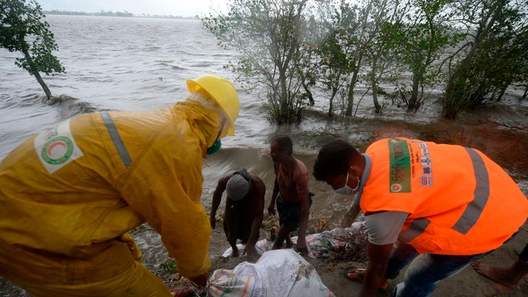 Les travailleurs et les villageois renforcent un remblai avec des sacs de terre avant l'arrivée prévue du cyclone Amphan, à Dacope, le 20 mai 2020. - Plusieurs millions de personnes se réfugiaient et priaient pour le meilleur mercredi en tant que cyclone le plus violent du golfe du Bengale depuis des décennies rugit vers le Bangladesh et l'Inde orientale, avec des prévisions d'une onde de tempête potentiellement dévastatrice et mortelle. Les autorités se sont efforcées d'évacuer les zones basses sur le chemin d'Amphan, qui n'est que le deuxième 