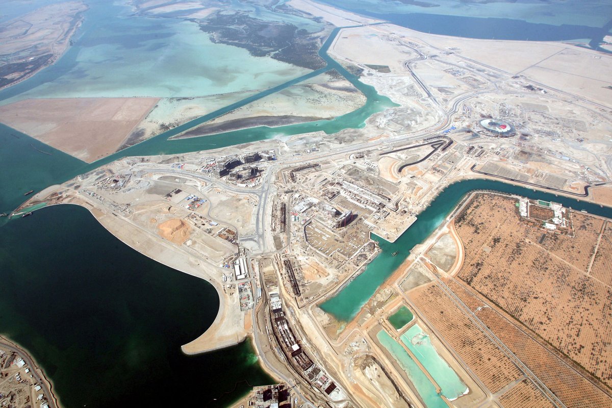 Vue aérienne de la marina, de la tribune principale, des bâtiments de la fosse, des bâtiments d'équipe, de l'hôtel Marina, de la piste, de la tribune nord et de l'île Yas