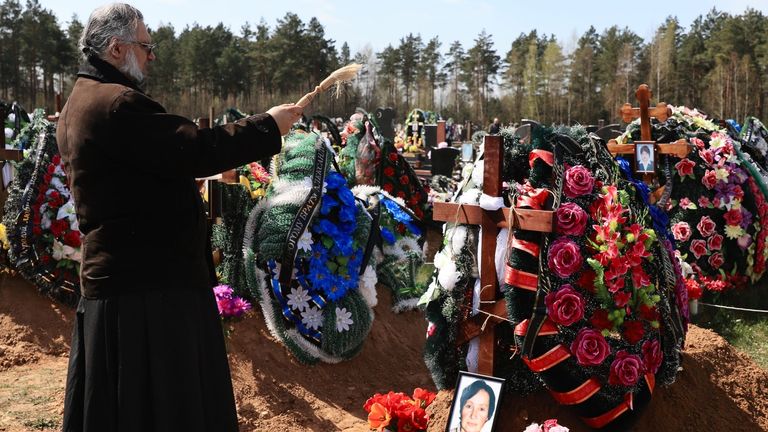Un prêtre bénit une nouvelle tombe où une victime biélorusse du COVID-19 a récemment été enterrée. Photo: Irina Alekhovskaya / Belsat