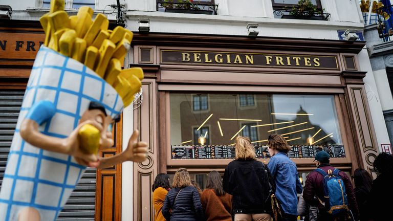 Les gens font la queue devant un vendeur de frites près de la Grand Place dans le centre de Bruxelles
