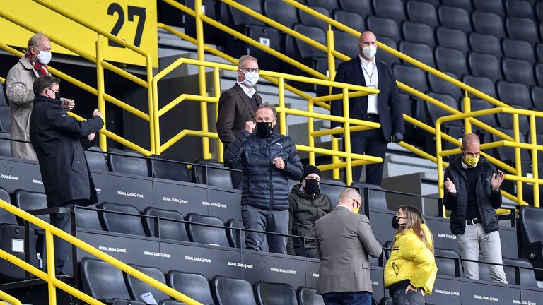 Hans-Joachim Watzke, PDG du Borussia Dortmund, centre portant un masque facial, fête avec les membres du conseil d'administration sur la tribune après le match