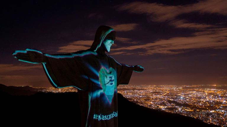 La statue du Christ Rédempteur est illuminée portant un masque facial appelant la société à les porter pour empêcher la propagation du nouveau coronavirus à Rio de Janeiro, Brésil le 03 mai 2020