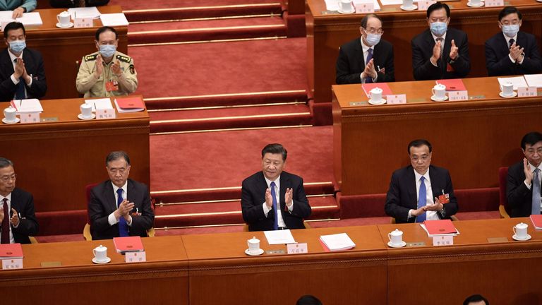 Le président chinois Xi Jinping (C) applaudit après que le Congrès national du peuple a approuvé une proposition de rédaction d'une loi sur la sécurité à Hong Kong