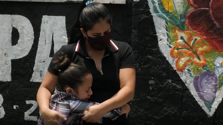 Une mère réconforte un enfant qui a perdu son oncle à cause de COVID-19 à Mexico