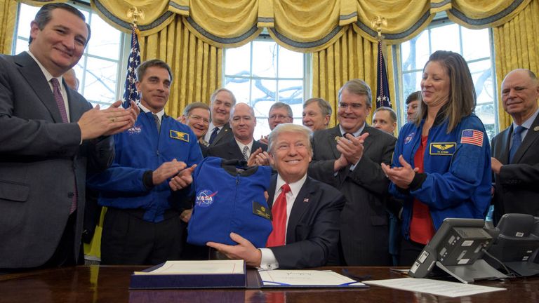 Le président Donald Trump, au centre, détient une veste de vol de la NASA qui lui est présentée par le chef du bureau des astronautes de la NASA Chris Cassidy, veste bleue à gauche, après avoir signé la NASA Transition Authorization Act of 2017, aux côtés de membres du Sénat, du Congrès et de la National Aeronautics and Space Administration dans le bureau ovale de la Maison Blanche à Washington, le mardi 21 mars 2017. Également sur la photo, le sénateur Ted Cruz, R-Texas, à gauche, le chef du bureau des astronautes de la NASA, Chris Cassidy, veste bleue à gauche, représentant du président du comité des sciences, Lamar Smith , R-Texas, représentant John Culberson, R-Texas, droit du président, astronaute de la NASA Tracy Caldwell Dyson, et autres. Crédit photo: (NASA / Bill Ingalls)