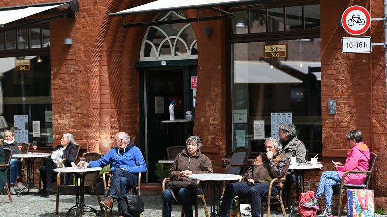 Les gens s'assoient à l'extérieur dans un café le premier jour, les restaurants et les cafés sont autorisés à rouvrir depuis mars 