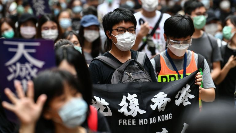 Les manifestants marchent sur une route lors d'un rassemblement pro-démocratie contre un nouveau projet de loi sur la sécurité à Hong Kong le 24 mai 2020. - Le projet de loi devrait interdire la trahison, la subversion et la sédition, et suit les avertissements répétés de Pékin qu'il ne tolèrent plus longtemps la dissidence à Hong Kong, qui a été ébranlée par des mois de manifestations antigouvernementales massives, parfois violentes, l'an dernier. (Photo par Anthony WALLACE / AFP) (Photo par ANTHONY WALLACE / AFP via Getty Images)