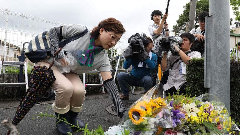 Des résidents déposent des fleurs pour les victimes de l'incendie