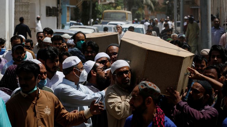 Des gens portent les cercueils de leur mari et de leur femme qui ont été tués dans un accident d'avion, lors d'un enterrement à Karachi