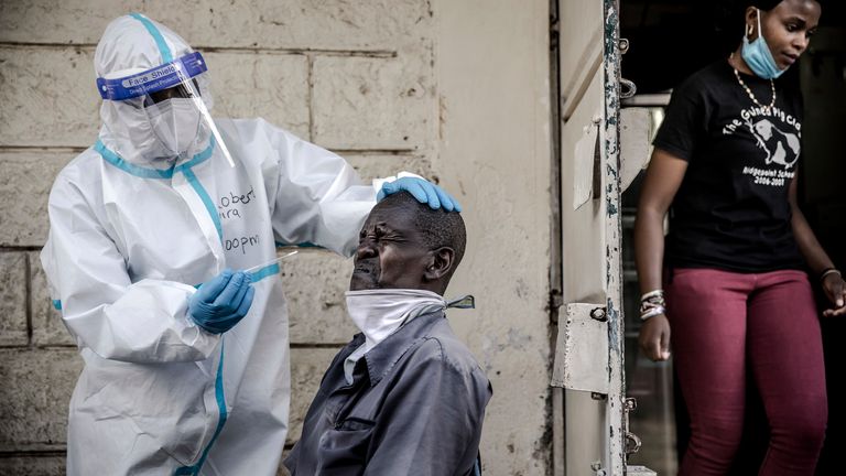 Un agent de santé porte un équipement de protection individuelle (EPI) lors de la collecte d'un écouvillon nasal au Kenya