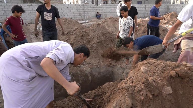 Des hommes creusent les grâces à la main au cimetière de Radhwan