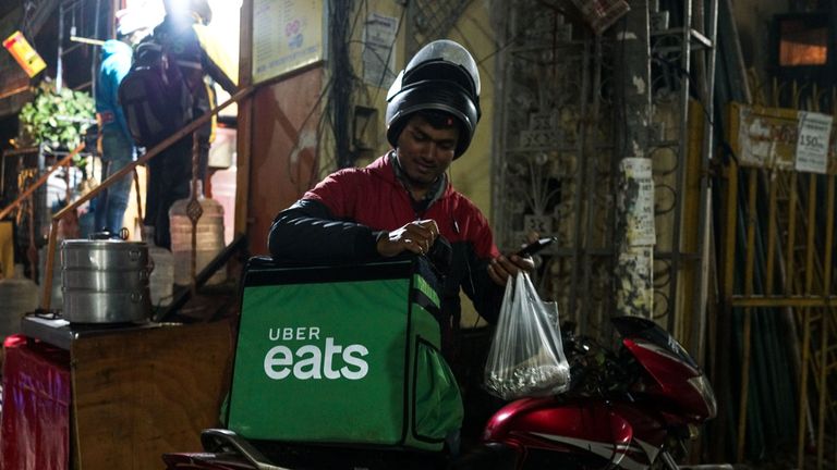 prise le 6 février 2019, un livreur indien travaillant avec l'application de livraison de nourriture Uber Eats charge de la nourriture à apporter à un client à New Delhi