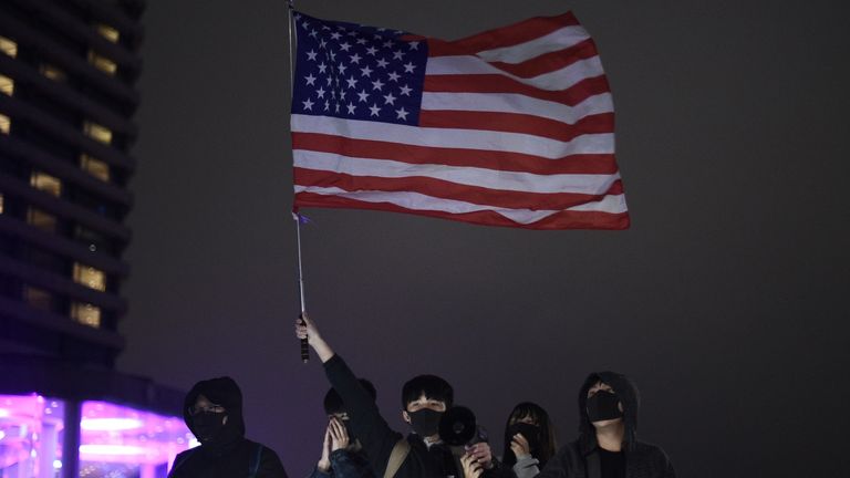 Les manifestants brandissent un drapeau américain à Hong Kong lors des célébrations du Nouvel An