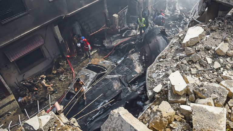 Des secouristes se rassemblent sur le site après qu'un avion de Pakistan International Airlines s'est écrasé dans un quartier résidentiel de Karachi le 22 mai 2020. - Un avion pakistanais avec près de 100 personnes à bord s'est écrasé dans un quartier résidentiel de la ville de Karachi, dans le sud du pays, le 22 mai. tuant plusieurs personnes sur le terrain. (Photo de Rizwan TABASSUM / AFP) (Photo de RIZWAN TABASSUM / AFP via Getty Images)