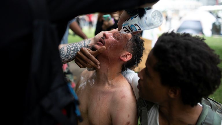 Un homme a de l'eau dans les yeux alors que les manifestants défilent à Denver