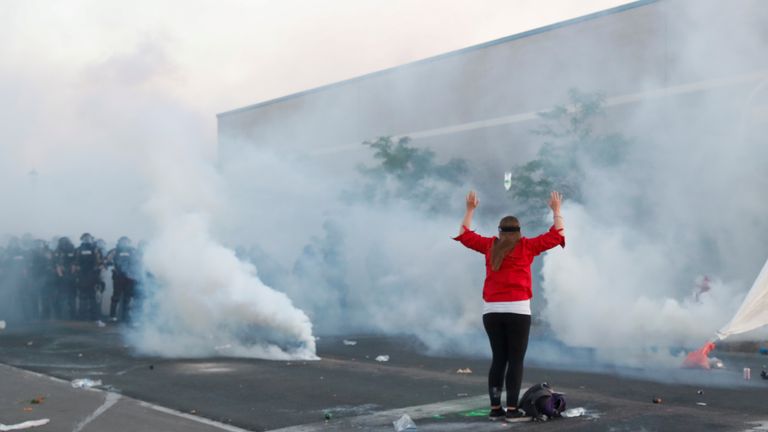 Un manifestant lève les bras devant les forces de sécurité à Minneapolis