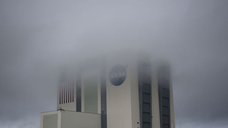 Le bâtiment d'assemblage de véhicules massif est entouré de brouillard alors que le temps orageux a accueilli le jour du lancement au Kennedy Space Center en Floride le 27 mai 2020. - Une nouvelle ère dans l'espace commence mercredi avec le lancement par SpaceX de deux astronautes de la NASA dans l'espace, une capacité qui pendant six décennies symbolisait le pouvoir d'une poignée d'États, et dont les États-Unis eux-mêmes étaient privés depuis neuf ans.Si le mauvais temps se dégage, à 16 h 33 (20 h 33 GMT), une fusée SpaceX avec la nouvelle Crew Dragon capsule sur