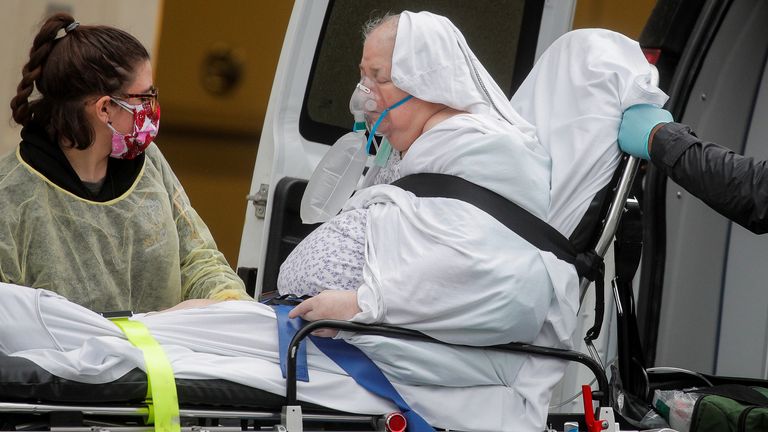 Les ambulanciers paramédicaux déchargent un patient dans un hôpital de Brooklyn