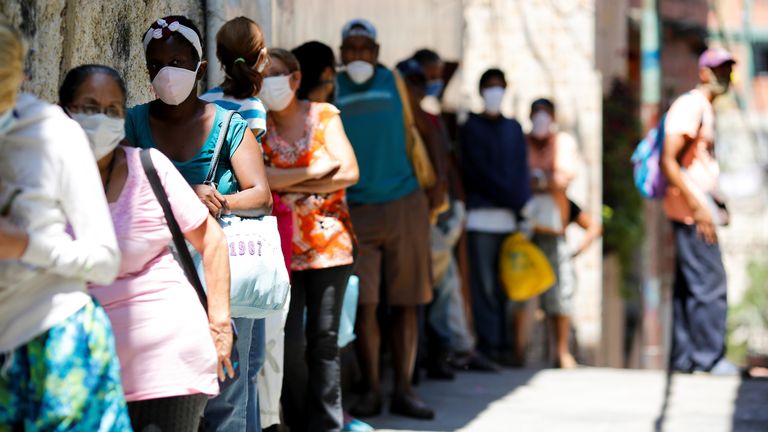 Les gens font la queue pour la nourriture d'un organisme de bienfaisance dans un bidonville de Caracas, au Venezuela, où l'économie du pays frappé par la pauvreté a été encore plus paralysée par COVID-19