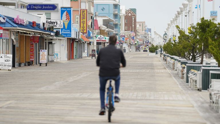 Un homme parcourt la promenade à vélo, un jour avant que les restrictions concernant la maladie à coronavirus (COVID-19) ne soient assouplies à Ocean City, Maryland, États-Unis, le 8 mai 2020. REUTERS / Kevin Lamarque