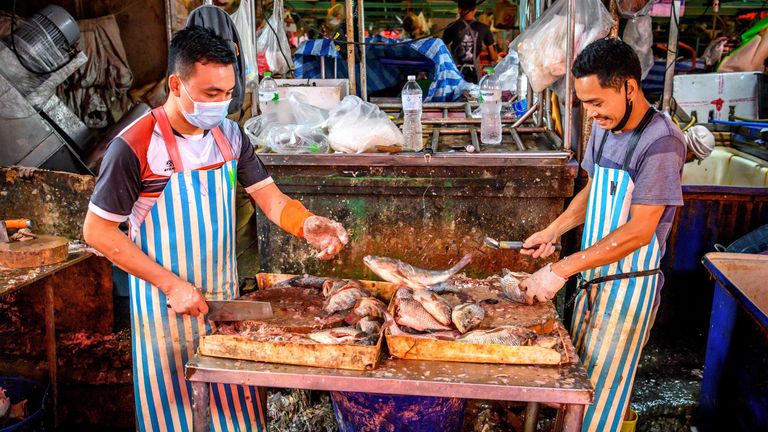 Un homme porte un masque au marché Khlong Toei à Bangkok