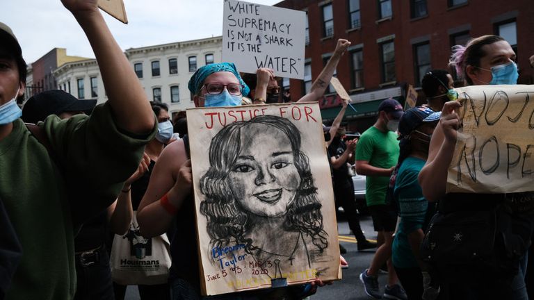 Une manifestante tient une photo de Breonna Taylor après sa mort