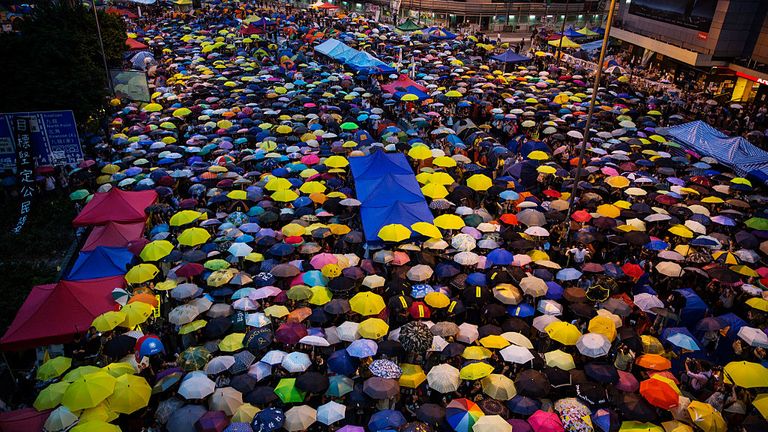HONG KONG - 28 OCTOBRE: Des parapluies sont ouverts alors que des dizaines de milliers de personnes arrivent sur le site principal de protestation un mois après que la police de Hong Kong a utilisé du gaz lacrymogène pour disperser les manifestants le 28 octobre 2014 à Hong Kong, Hong Kong. Une atmosphère paisible et sûre demeure sur le site de protestation massif alors que les artistes s'expriment librement et que les familles amènent leurs enfants à vivre la révolution des parapluies. (Photo par Paula Bronstein / Getty Images)
