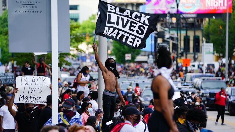 Un homme brandit un drapeau Black Lives Matter lors d'une manifestation contre la mort de George Floyd à Minneapolis alors qu'il était en garde à vue à l'extérieur de CNN Center le 29 mai 2020 à Atlanta, en Géorgie. (Photo par Elijah Nouvelage / Getty Images)