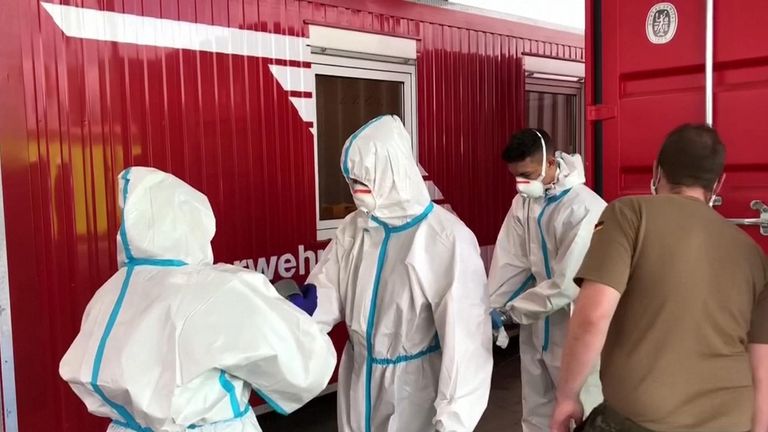 Les travailleurs de la transformation de la viande de Toennis portent des vêtements de protection pour éloigner le coronavirus