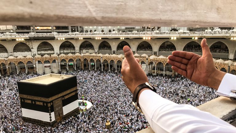 Un pèlerin musulman prie tandis que d'autres encerclent la Kaaba et prient à la Grande Mosquée avant le pèlerinage annuel du Haj dans la ville sainte de La Mecque, en Arabie Saoudite 