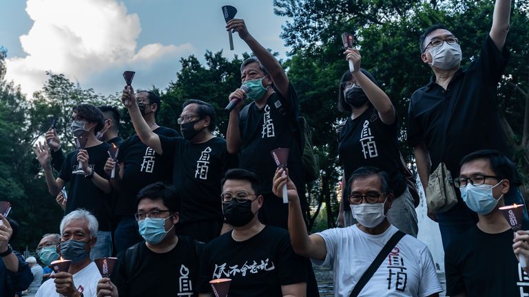 Des militants pro-démocratie tiennent des bougies et crient des slogans 