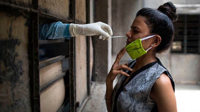 Une femme est testée pour le COVID-19 dans un établissement temporaire gratuit dans une école de New Delhi, en Inde