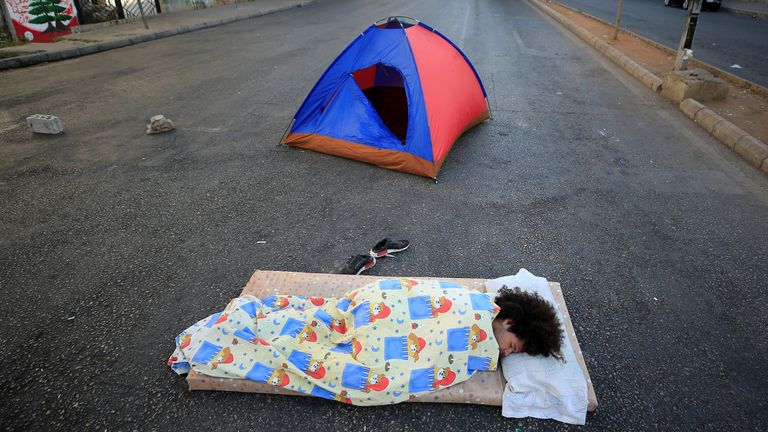 Un manifestant gît par terre pour bloquer une route à Sidon