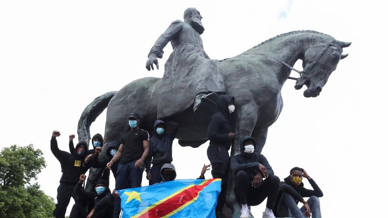 Des manifestants se tiennent sur la statue de Léopold II, dans le centre de Bruxelles