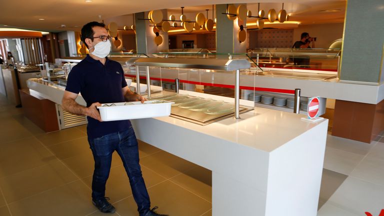 Un travailleur portant un masque protecteur prépare le buffet dans un hôtel de la plage Playa de Palma