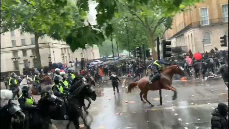 Au moment où un policier frappe un feu de circulation en montant à cheval. 