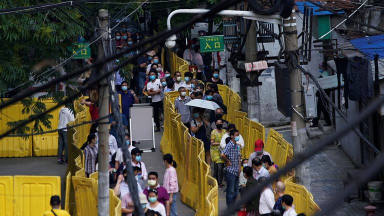 Des résidents portant des masques faciaux font la queue pour des tests dans un complexe résidentiel à Wuhan