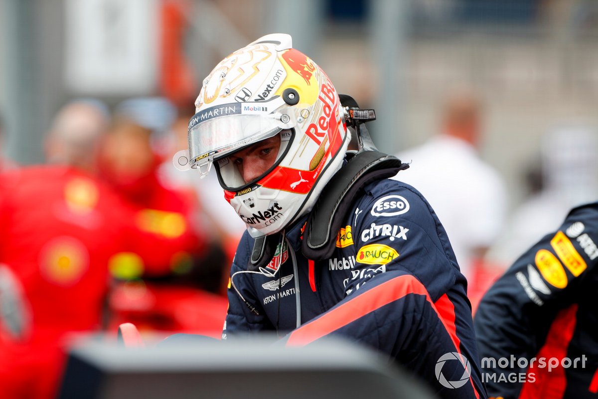 Un Max Verstappen à face rouge, Red Bull Racing, sort de sa voiture accidentée sur la grille
