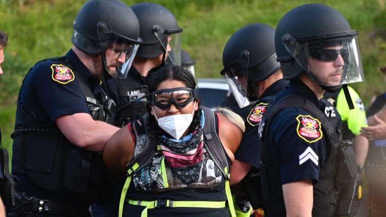 La police arrête un manifestant portant un masque facial alors que des militants et des membres de différentes tribus de la région ont bloqué la route du monument national du mont Rushmore à Keystone, Dakota du Sud le 3 juillet 2020, lors d'une manifestation autour du monument national du mont Rushmore et de la visite des États-Unis. Le président Donald Trump.  (Photo par ANDREW CABALLERO-REYNOLDS / AFP) (Photo par ANDREW CABALLERO-REYNOLDS / AFP via Getty Images)