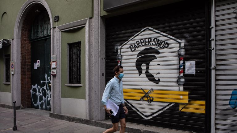 MILAN, ITALIE - 6 MAI: Un homme, portant un masque protecteur, passe devant un salon de coiffure à volets le 6 mai 2020 à Milan, en Italie.  L'Italie a été le premier pays à imposer un verrouillage national pour endiguer la transmission du coronavirus (Covid-19), et ses restaurants, théâtres et de nombreuses autres entreprises restent fermés.  (Photo par Emanuele Cremaschi / Getty Images)