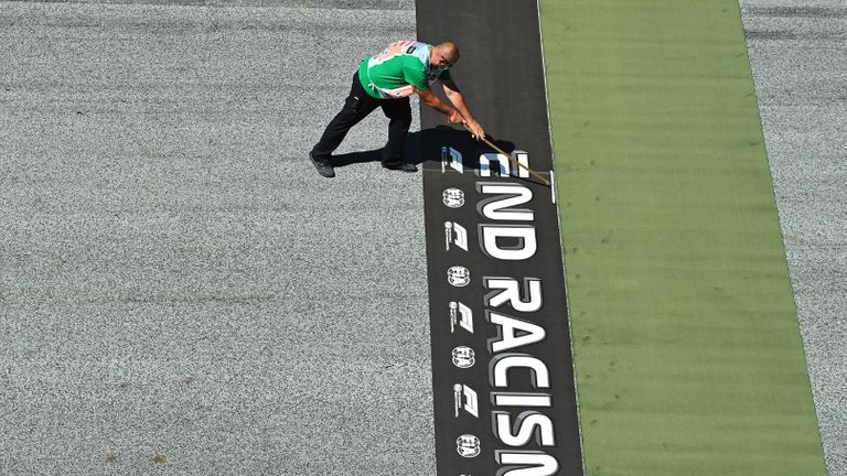 SPIELBERG, AUTRICHE - 05 JUILLET: Un membre du personnel au sol prépare une bannière sur la bonne voie pour `` mettre fin au racisme '' avant le Grand Prix de Formule 1 d'Autriche au Red Bull Ring le 5 juillet 2020 à Spielberg, en Autriche.  (Photo par Joe Klamar / Piscine via Getty Images)