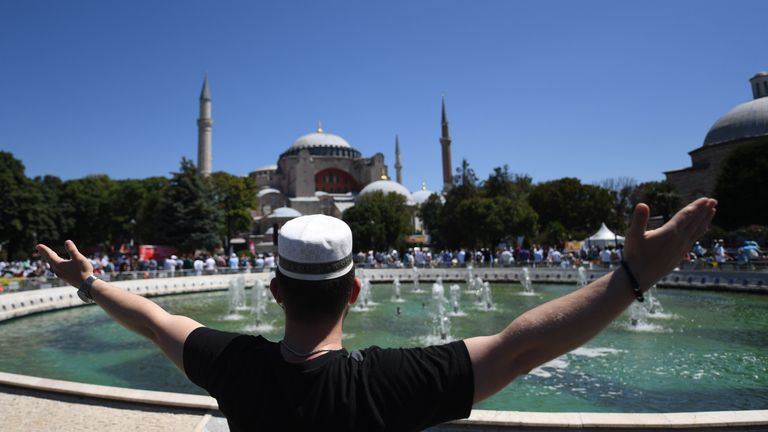 Un homme lève les bras alors que les gens se rassemblent le 24 juillet 2020 devant Sainte-Sophie à Istanbul pour assister à la prière du vendredi, la première prière musulmane tenue au monument depuis qu'il a été reconverti en mosquée malgré la condamnation internationale.  - Un tribunal turc de haut niveau a révoqué le statut de musée du sixième siècle le 10 juillet et le président turc a ensuite ordonné la réouverture du bâtiment pour le culte musulman.  Le site du patrimoine mondial de l'UNESCO dans la ville historique d'Istanbul a d'abord été construit comme une cathédrale dans l'Empire byzantin chrétien, mais a été converti en mosquée après la conquête ottomane de Constantinople en 1453. (Photo par OZAN KOSE / AFP) (Photo par OZAN KOSE / AFP via Getty Images)