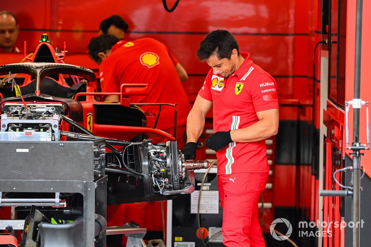 Ferrari mechnanics au travail dans le garage de l'équipe sur un SF1000 