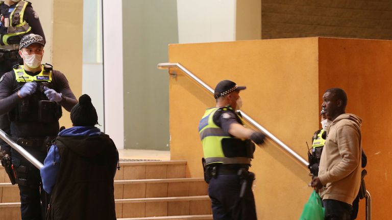 Un officier de police parle à un homme en tant qu'officiers de faire respecter un `` verrouillage strict '' dans un immeuble de logements sociaux à Melbourne
