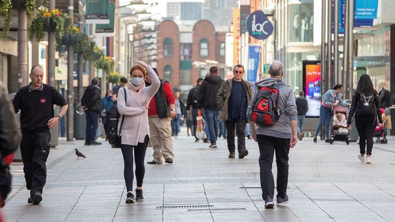 Certaines personnes portent des masques faciaux en passant devant les magasins de Dublin