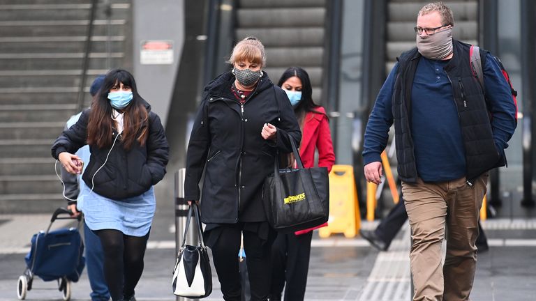 On voit des gens marchant dans Melbourne où les masques faciaux sont obligatoires 