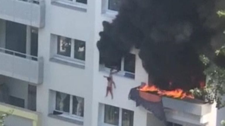 L'enfant est suspendu au bâtiment en feu.
