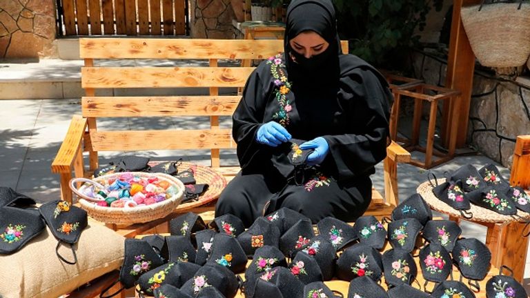 Une femme près d'Hébron fabrique des masques faciaux - on a également dit aux habitants de Cisjordanie de rester à la maison